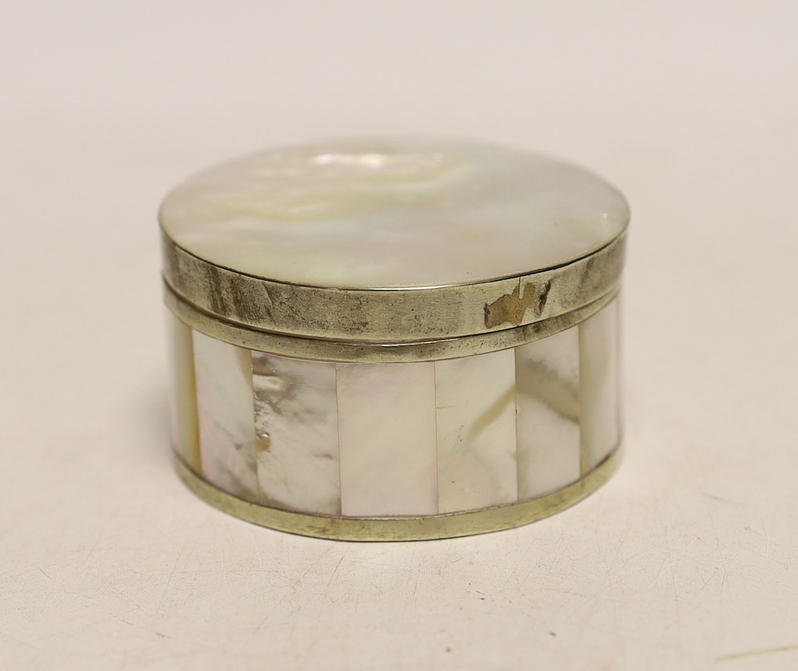 A white metal mounted mother of pearl circular box and cover, diameter 62mm.